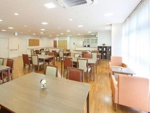 ４人掛けのテーブルがいくつも並べられている。窓際にはピンク色のソファチェアがテーブルを挟んで向かい合わせに置かれている。