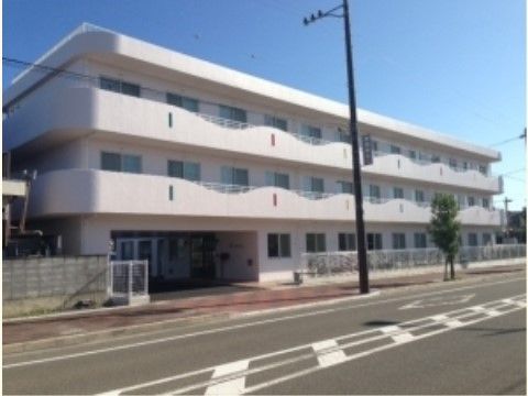 目の前に大きな道路がある、白を基調とした３階建ての住宅