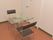 装飾品などが一切置かれていないスッキリとした部屋。ガラスのテーブルに2脚の椅子が対面するように配置されている。