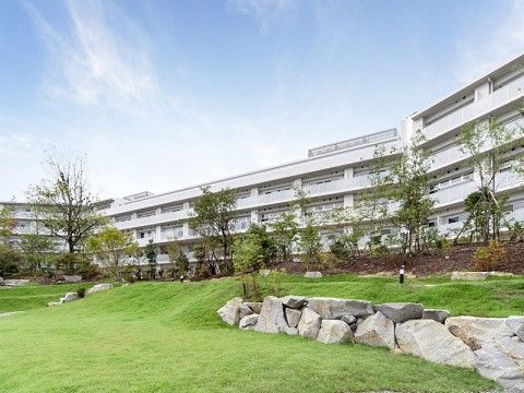 施設敷地内にある大きな庭園に広がる青い芝生と緑の木々