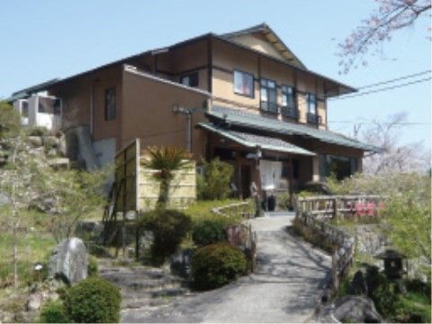エントランス前の庭園が美しい、２階建ての和テイストな建物
