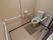 広いトイレである。全ての壁と便器の両側に手すりが設置されており、緊急時呼出しボタンが備えられている。