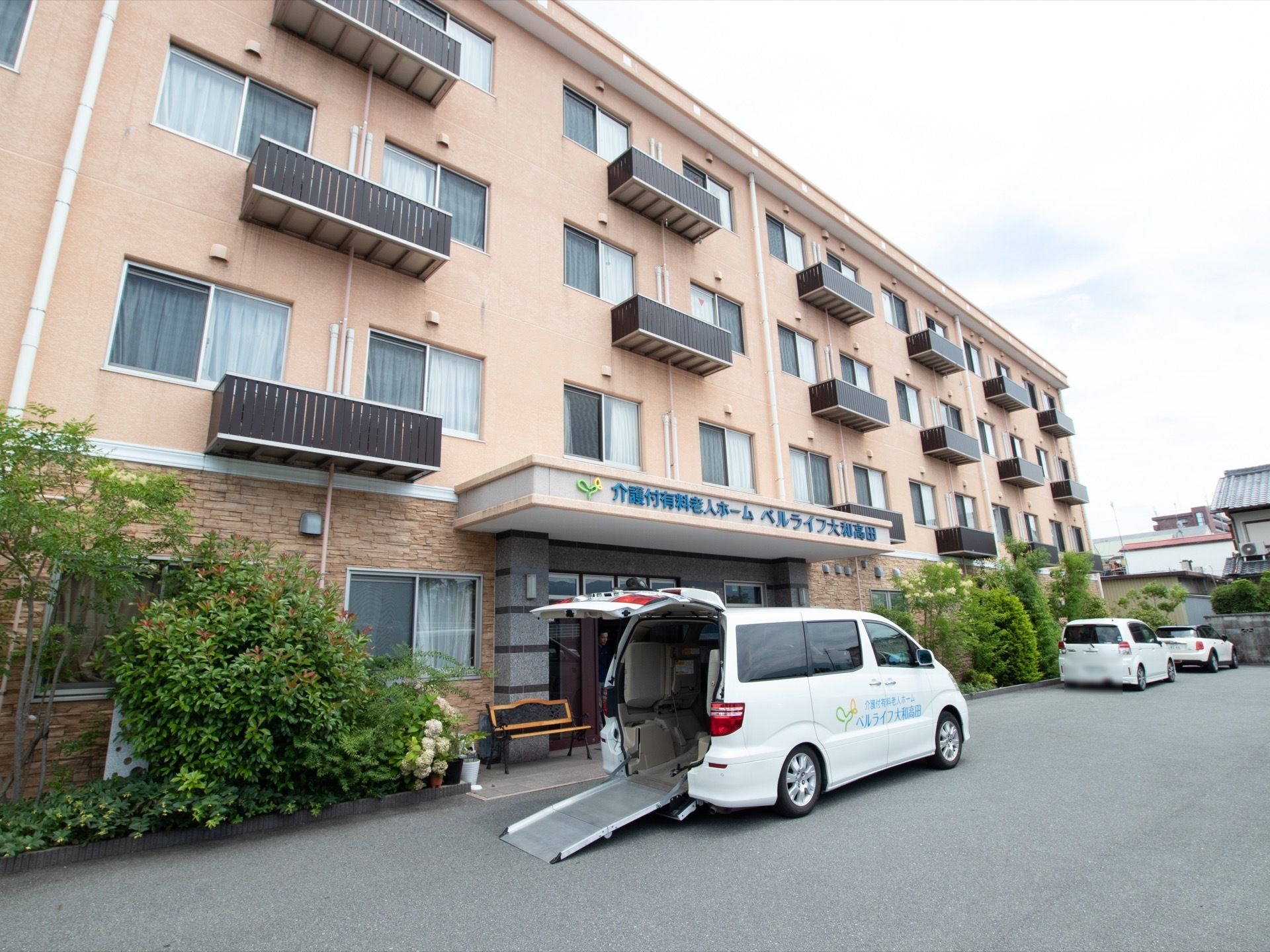 一階部分の壁には、レンガ調のタイルが敷き詰めてある。そして２階以上の壁面はレンガ色である。玄関前には車を寄せる場所を作っている。