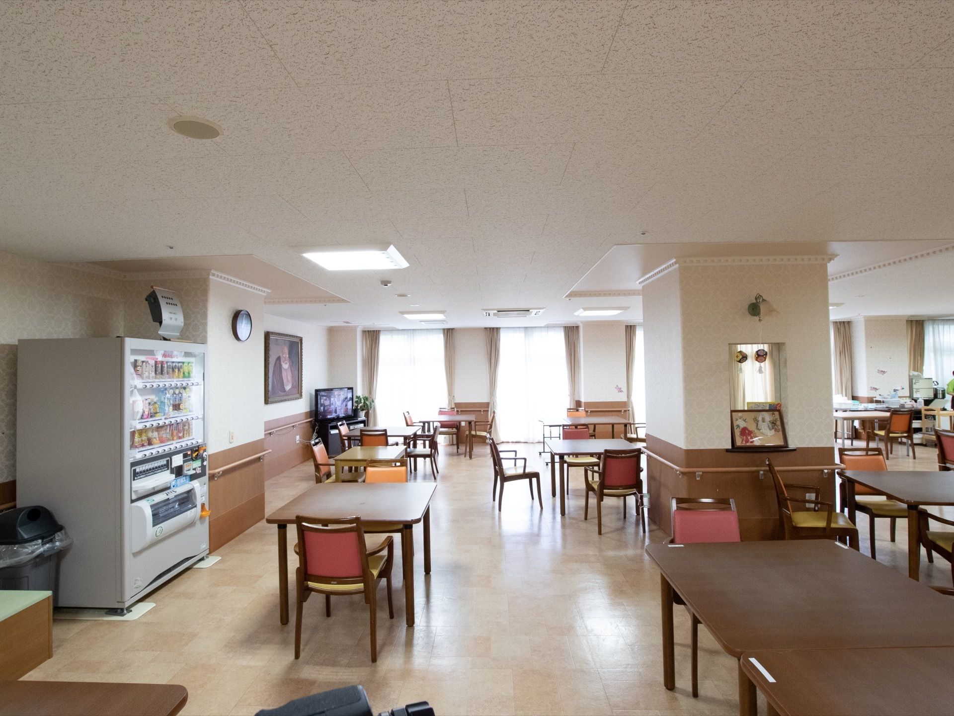 食堂の一角には自動販売機があり、自由に清涼飲料水が購入できる。角にテレビを設置して、入居者様が共有している。