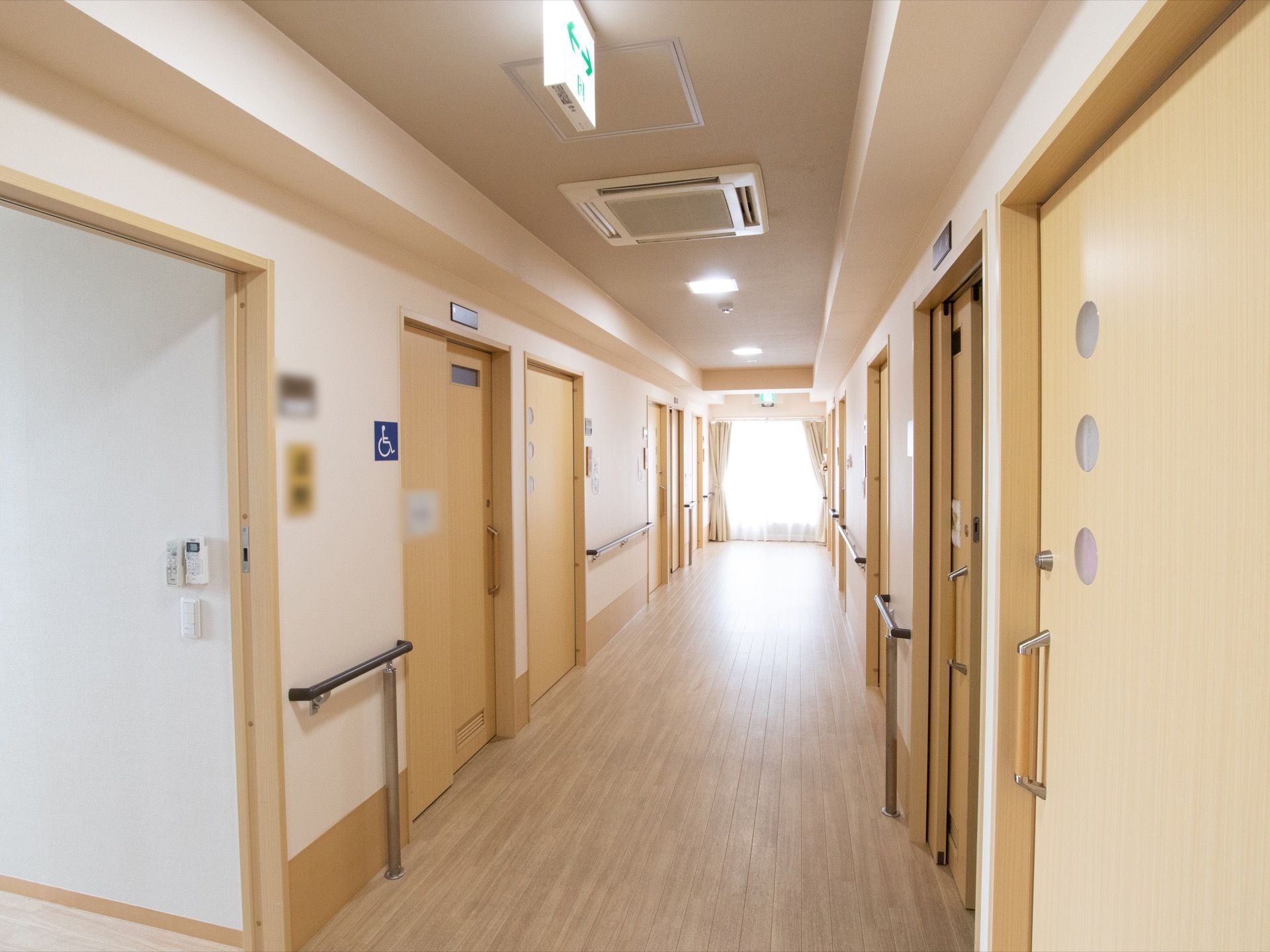 明るく見通しが良い通路。壁には手すりを設置している。部屋からは、引き戸を開けて、段差なく通ることができる。