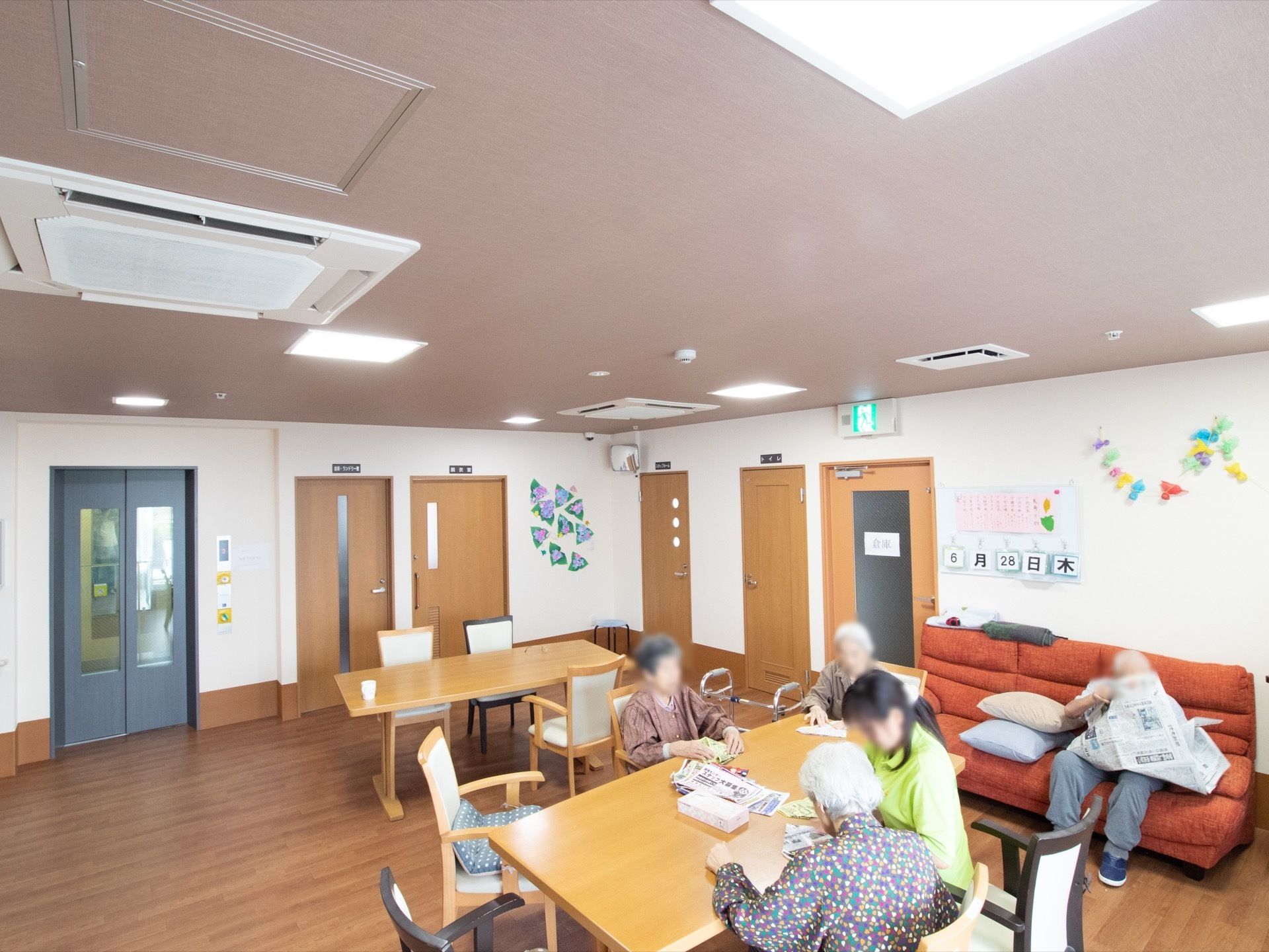 机や椅子の数を必要最低限に留め、活動スペースを十分に確保している。壁には入居者様の作品を展示している。
