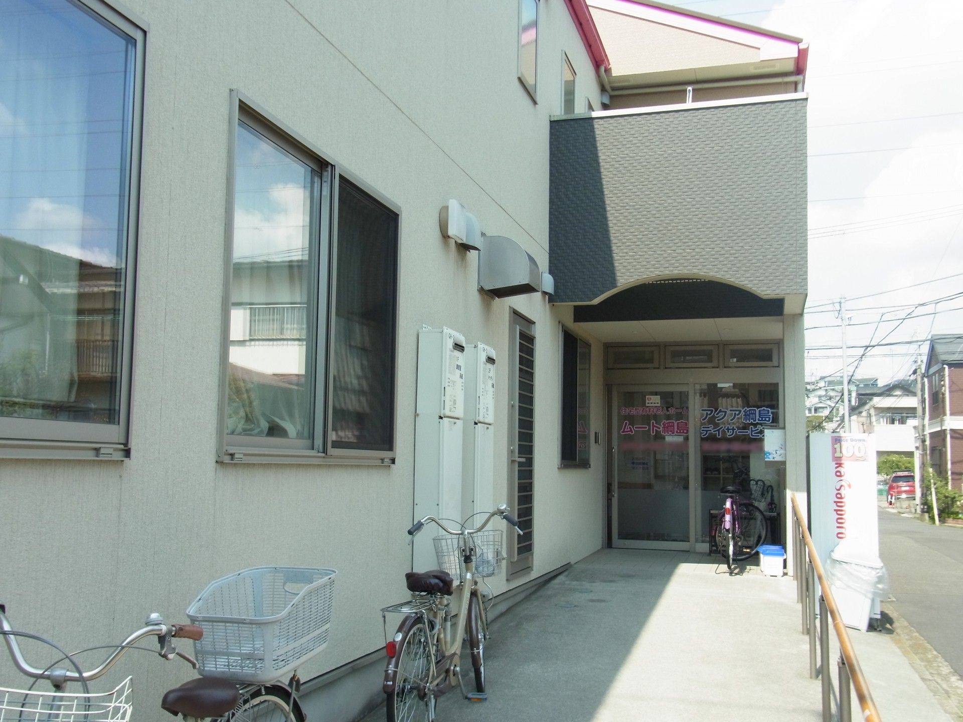 玄関の前の屋根があるスペースに続く、傾斜の穏やかなスロープがある。通路の幅が広く、手すりが備わっている。