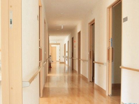 廊下はゆったり広々としているので、車椅子をご利用の方も楽に通れる。両側には各居室の引き戸が並んでいる。