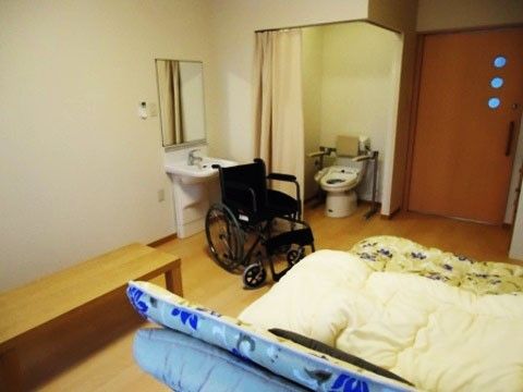 広々とした居室内には、トイレや洗面スペース、介護用ベッド、長椅子が完備されている。車椅子を乗り入れるスペースがある。
