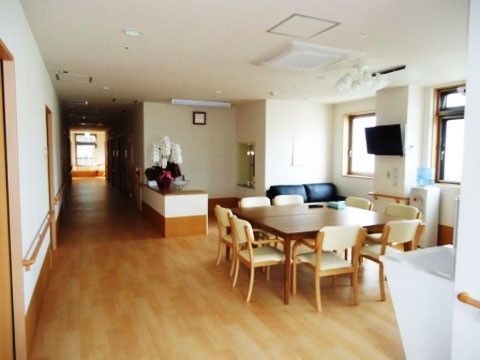 ゆったりとした明るい食堂には、８人掛けのダイニングテーブルと大型液晶テレビ、エアコンが完備されている。