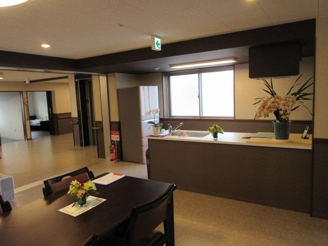 リビングは入居者様が楽しく過ごせるように、かわいらしい飾り付けがしてある。テーブルの上の一輪挿しには、花が活けてある。