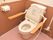 茶色の内装にピンクの床がおしゃれなトイレ。手すりのついたバリアフリー設計。