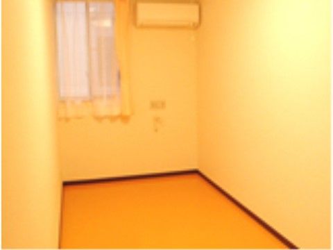 窓にカーテンがかかっている。内装はあたたかなクリーム色で統一されている。