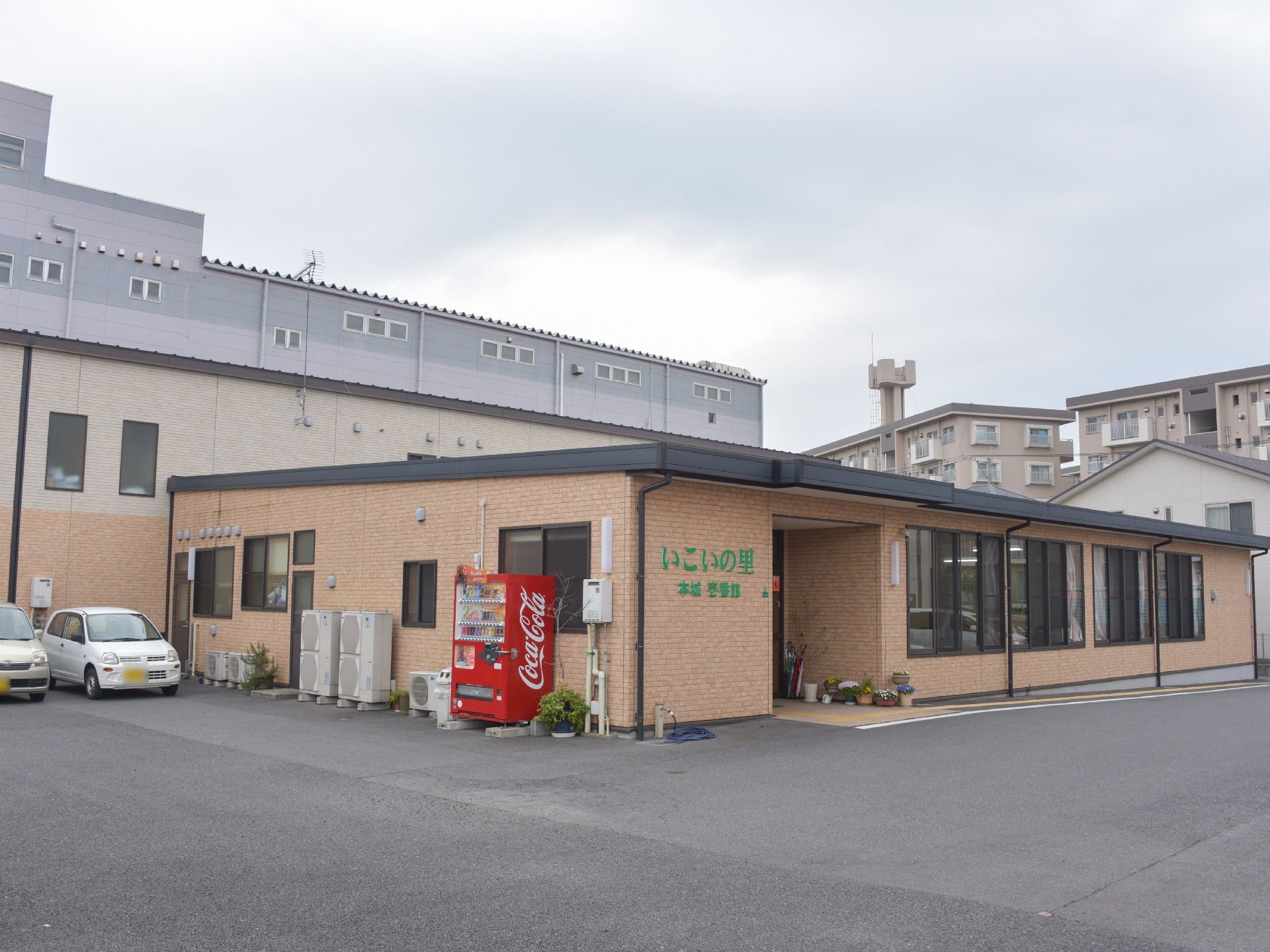 建物の壁はうすい茶系で落ち着いた雰囲気である。玄関そばに広い駐車場が完備。車でお越しの方に便利である。