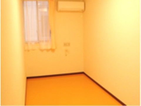 窓にカーテンがかかっている。内装はあたたかなクリーム色で統一されている。