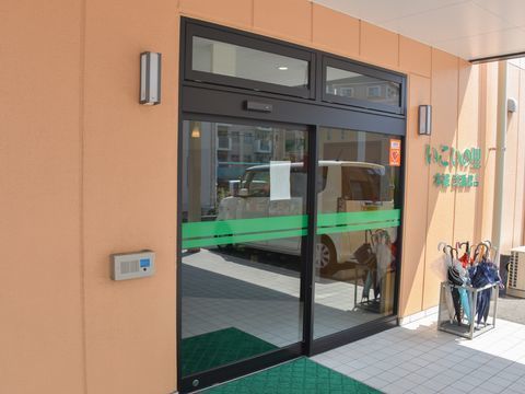 ガラス張りの自動ドアが設置された、屋根付きのエントランス