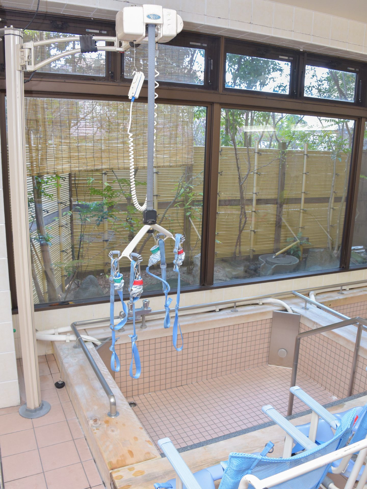 体が不自由でひとりでは浴槽に入れない方にもリフト入浴を完備。介助してもらいながら外の木々も眺められるよう、配慮している。