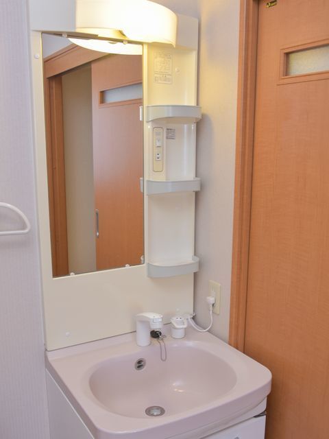 鏡に向かって右側に、化粧品やコップなどを入れるのにちょうど良い間隔で棚が3つついています。顔色をよく見せる暖色のライト付き。