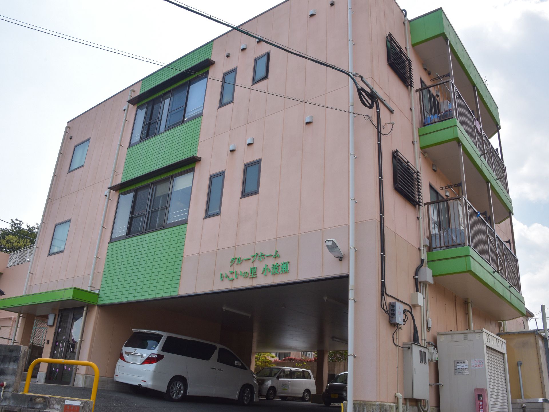 ピンクにグリーンが映えて可愛らしい外観をもつ3階建ての建物。駐車場もしっかり確保され、働く人にも利用者にも配慮している。