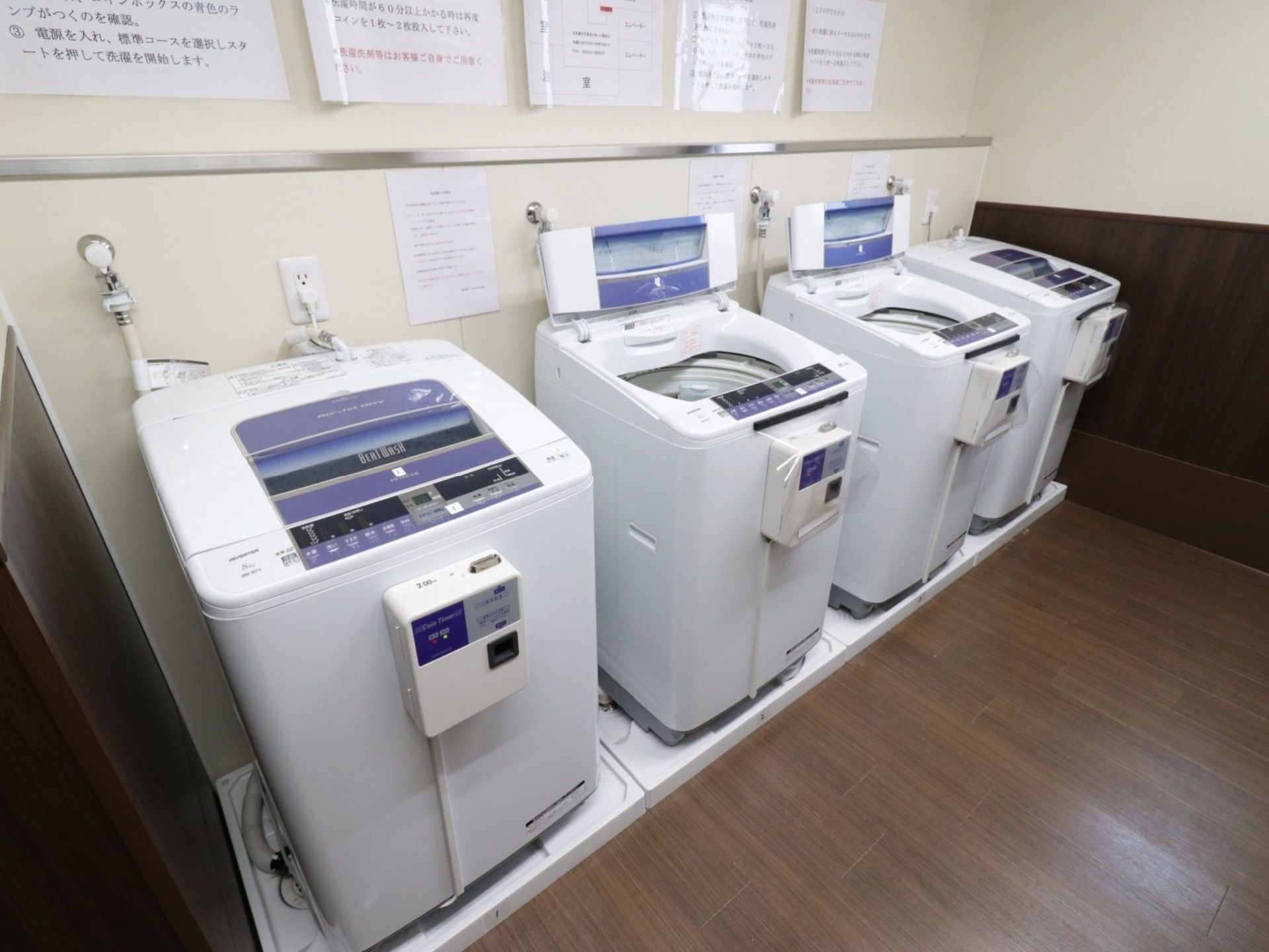 14階に設置されたコインランドリー室。洗濯機が4台並び、真ん中の2台には液晶の操作表示板が付いている。