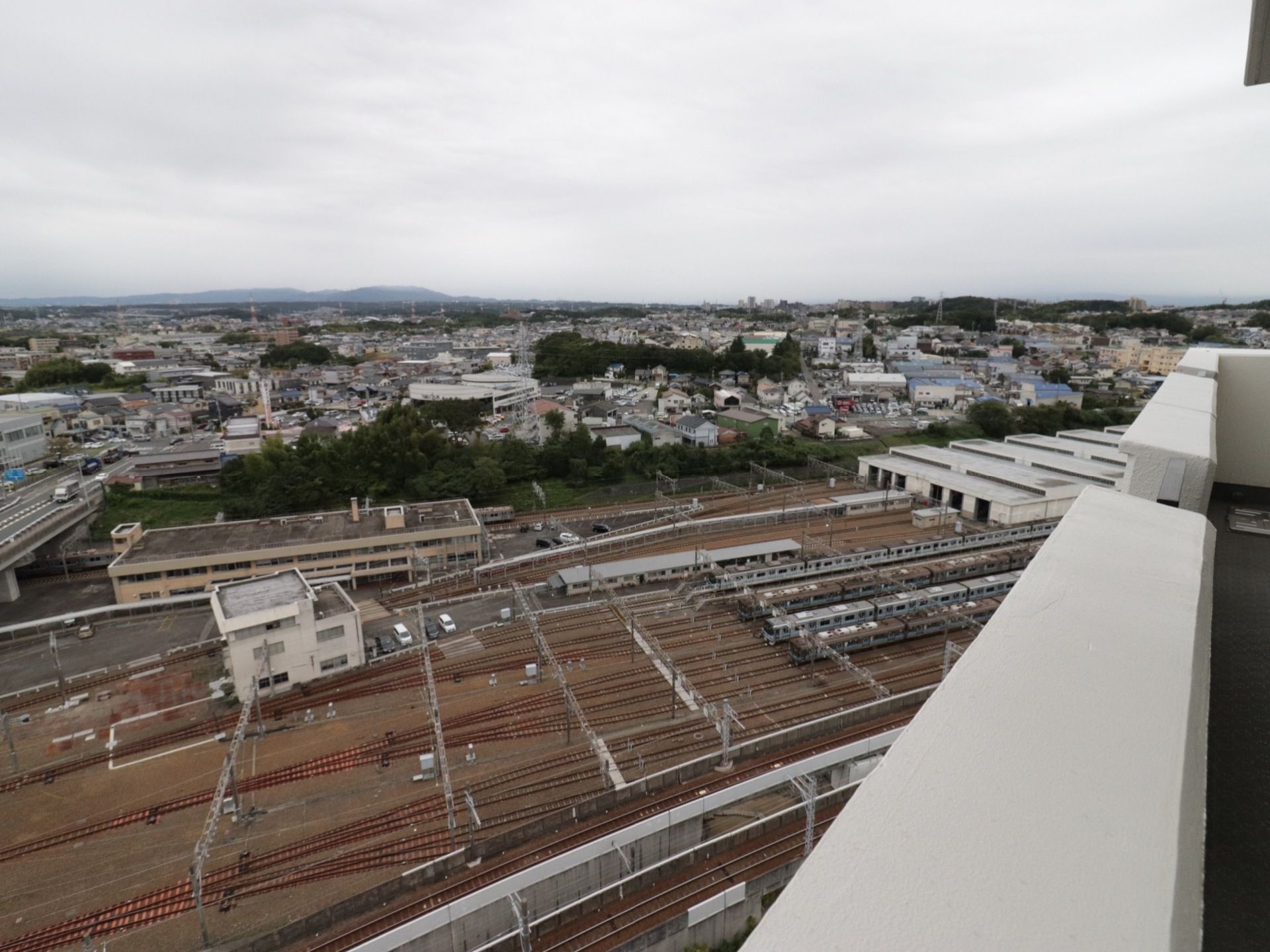 ベランダから見下ろした位置に見える名鉄豊田線の操車場の風景。数多くの線路と車両とが、壮観な眺望を形成している。