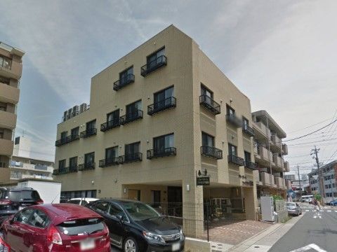 住宅街の中にある、ブラウンを基調としたお洒落な４階建ての建物