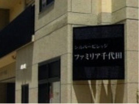 建物の外壁に取り付けられた、施設名が書かれた黒い看板
