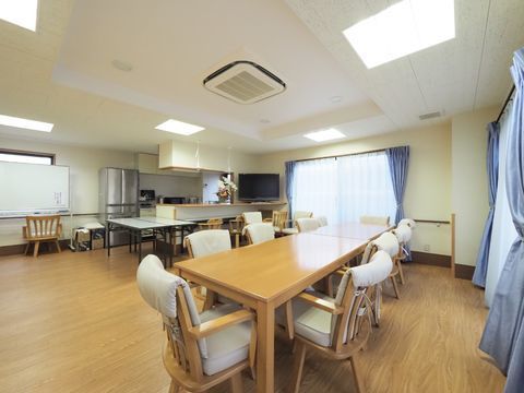 大きなカウンターキッチンが併設された、テレビのあるダイニング