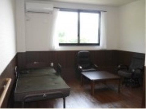 エアコンが完備され、ベッドやテーブルなどの家具が置かれた部屋