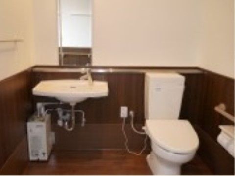 トイレの脇には鏡付きの洗面台が設置されている。車椅子でも近くに着けるよう、足元に空間が設けられている。
