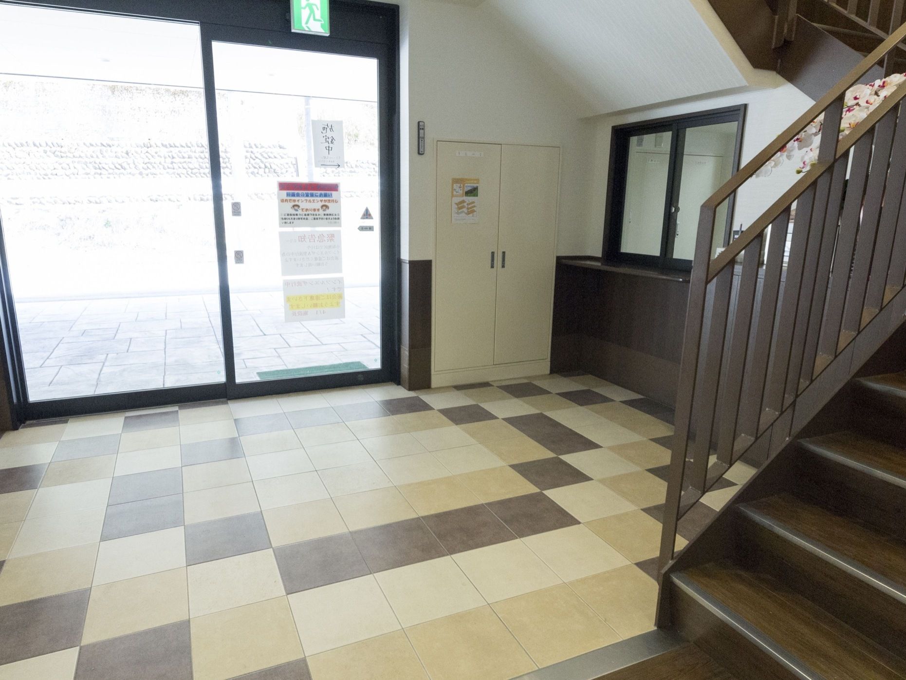 出入口の前には焦げ茶色の階段が設置されており、入居者様は入室後に直接階段を使用して居室に向うことができる。