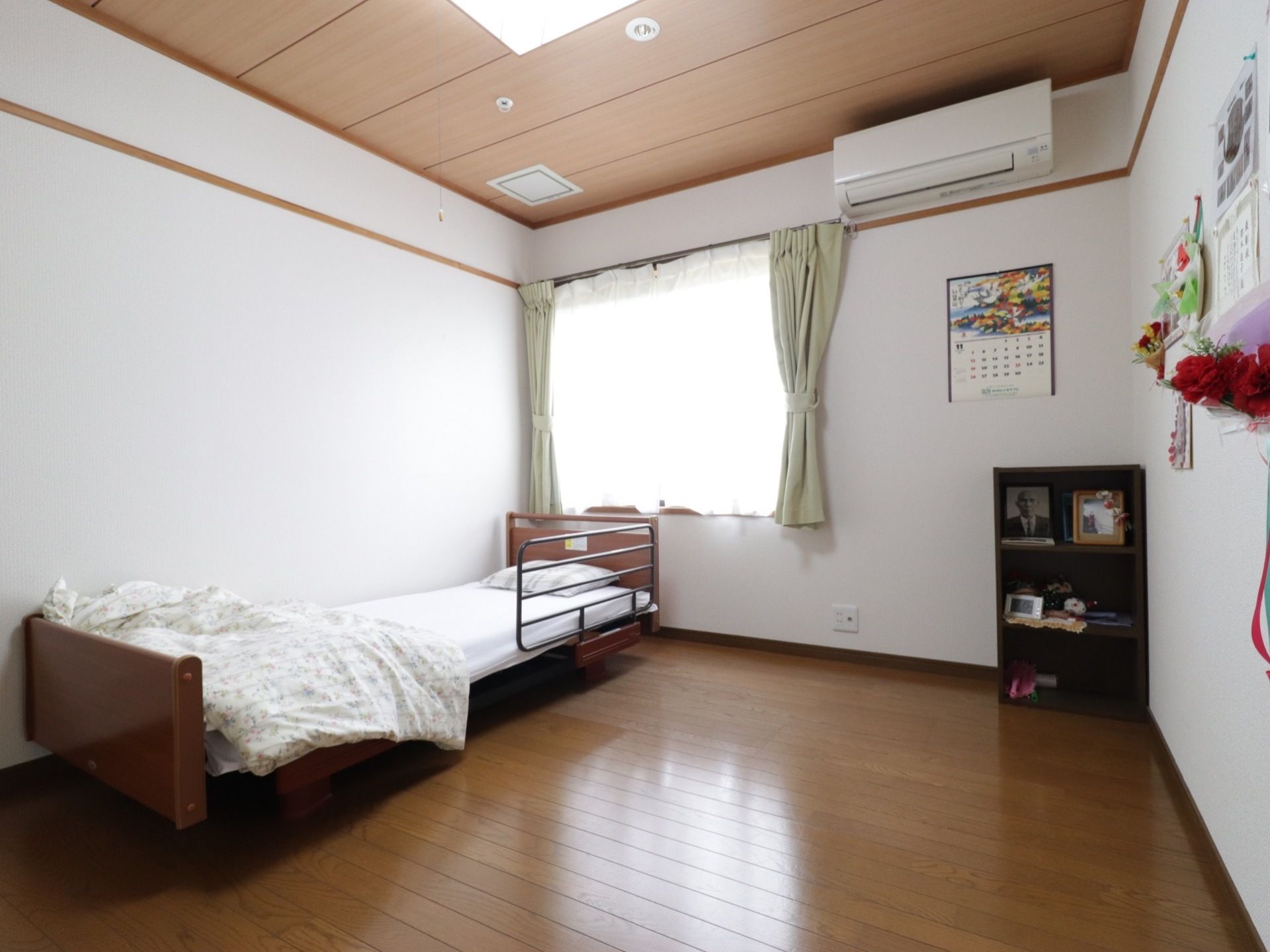 居室の壁際に置かれている、転落防止柵がついたベッド