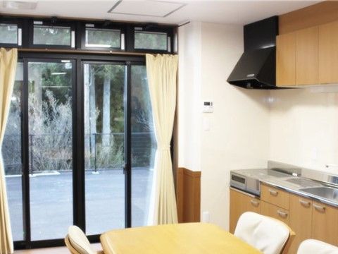 正面は大きな掃き出し窓で、窓に向かい右手の壁には台所がある。奥から電磁調理器、調理台、流しが並んでいる。