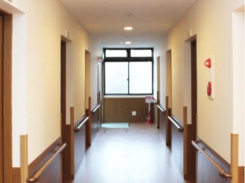 廊下は正面に窓があり、両側に居室ドアが並んでいる。ドアの間の壁には手すりがあり、角にはそれぞれガードが付いている。
