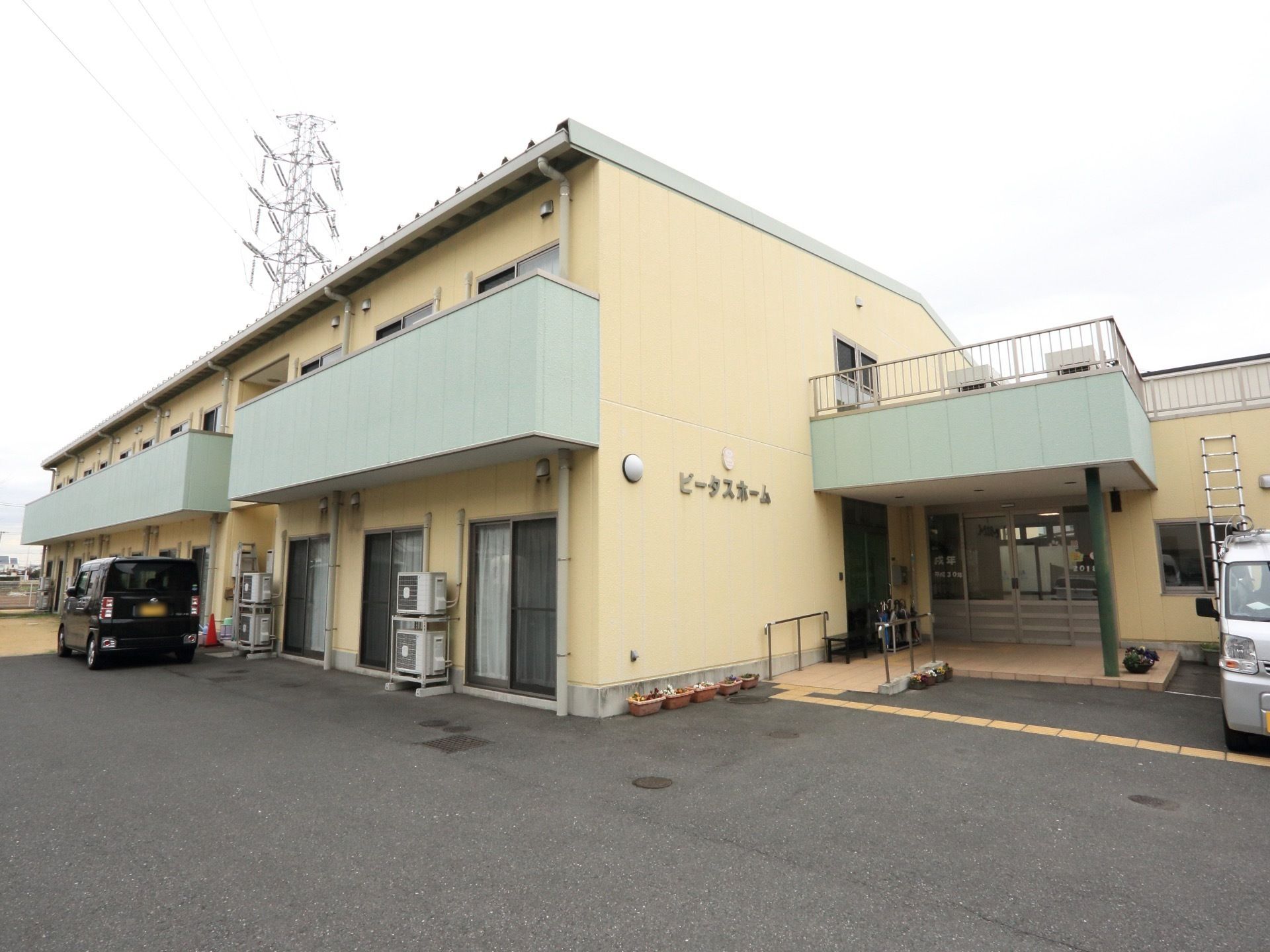 エントランス前に、広い駐車スペースを確保している。外壁には、分かりやすく施設名が大きく表示されている。