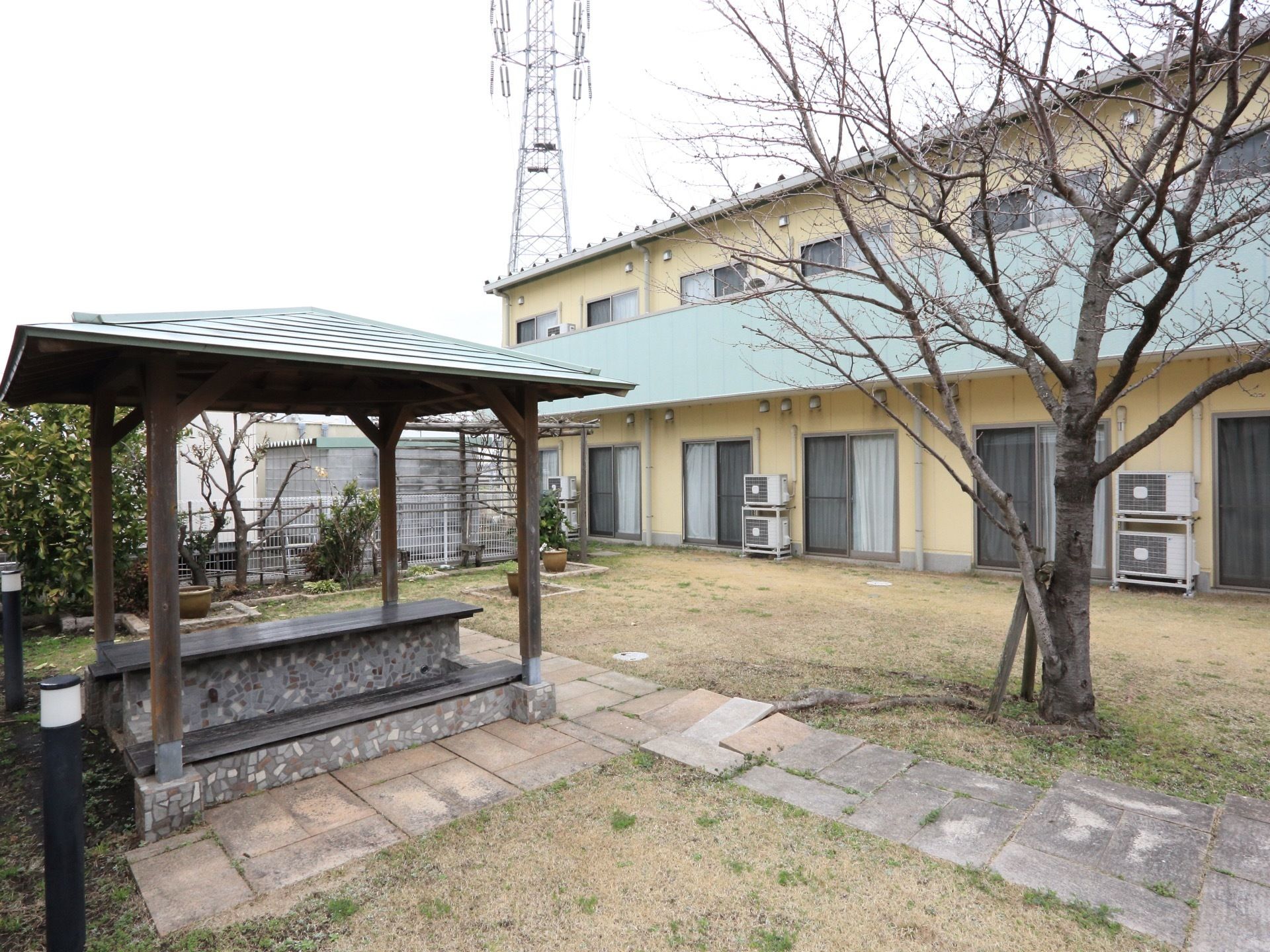 緑あふれる中庭には、屋根の付きの足湯スペースがある。真ん中のテーブルを挟み、ベンチが２脚設置されている。