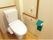 トイレの便座左側には、くの字に曲がった手すりを設けている。足が不自由な入居者様がご自身でトイレに入るための工夫がある。