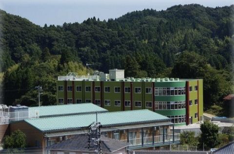 すぐ後ろに山並みがある場所に立地している施設の遠景