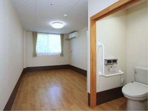 居室に入ってすぐの所にある、ふたが付いた便器が設置されているトイレ