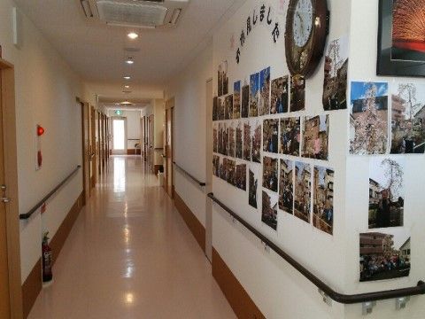 長く伸びる廊下。両側の壁には手すりが付いており、左壁には火災報知器と消火器も設置されている。突き当たりは非常口になっている。