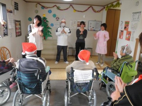 季節にちなんだイベントで、赤い帽子をかぶって舞台を見ている入居者様たち