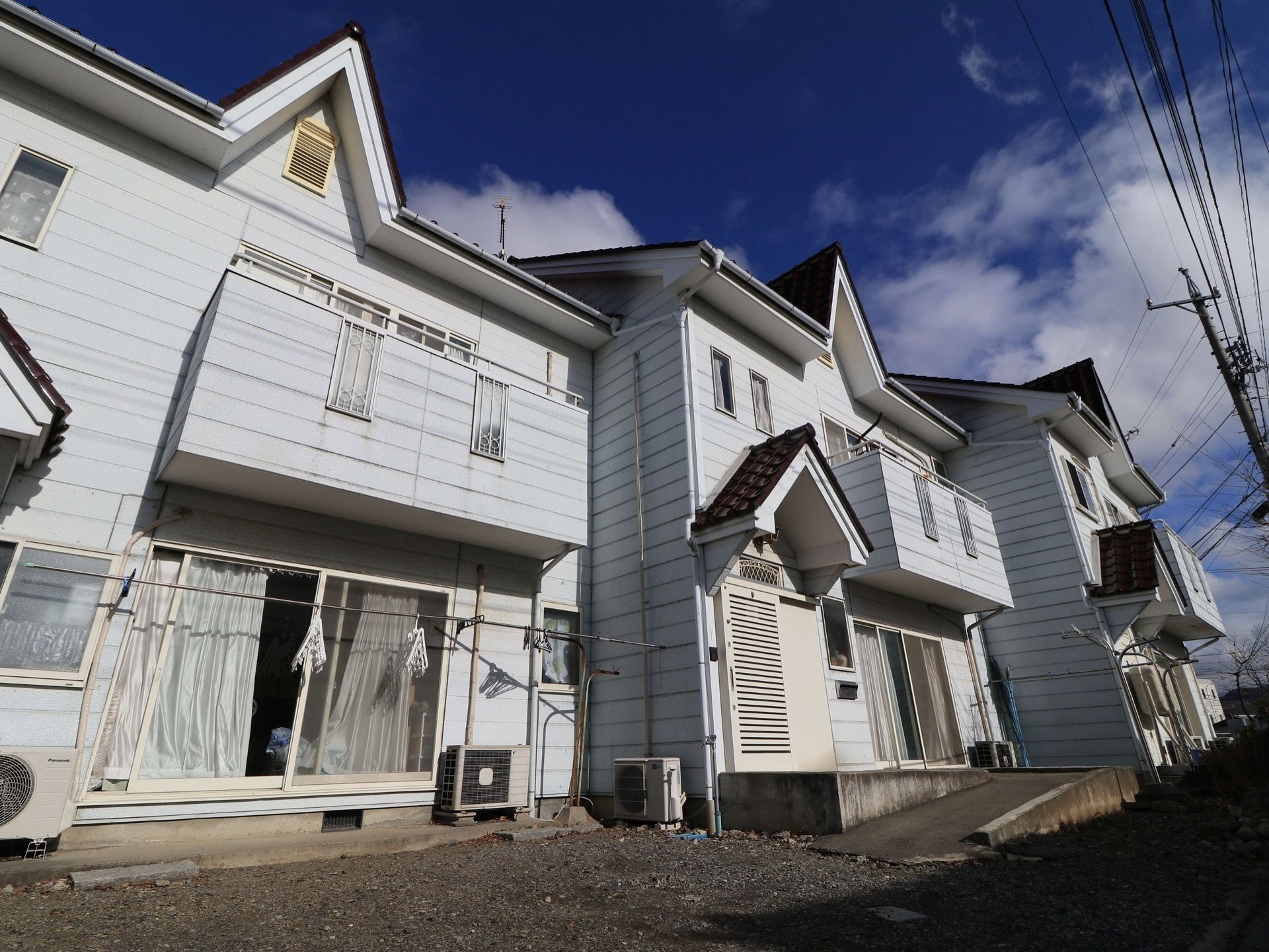 白い壁にブラウンの屋根の洋風アパートのような外観をしている。玄関まではスロープになっており、玄関扉は引き戸になっている。