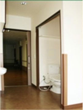 居室に設置された温水洗浄機能付きトイレである。車椅子をご利用の方も不自由なく使用できるように、ドアがない。
