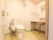 白とクリームのトイレスペースである。横側に大きな鏡のある洗面台を設置している。横の壁にタオル掛けを取り付けている。