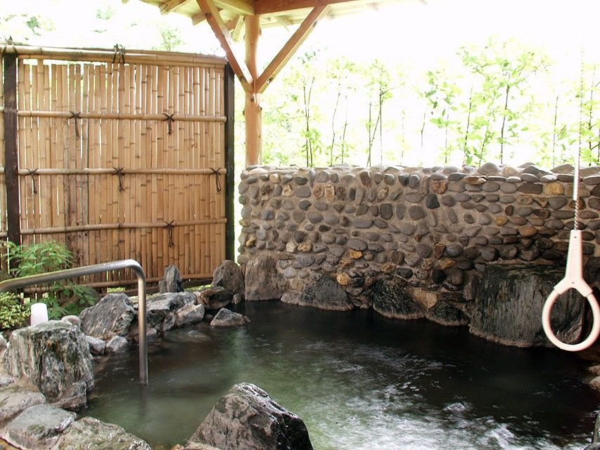 東屋風の建屋の下にある、垣根で目隠しされている露天風呂