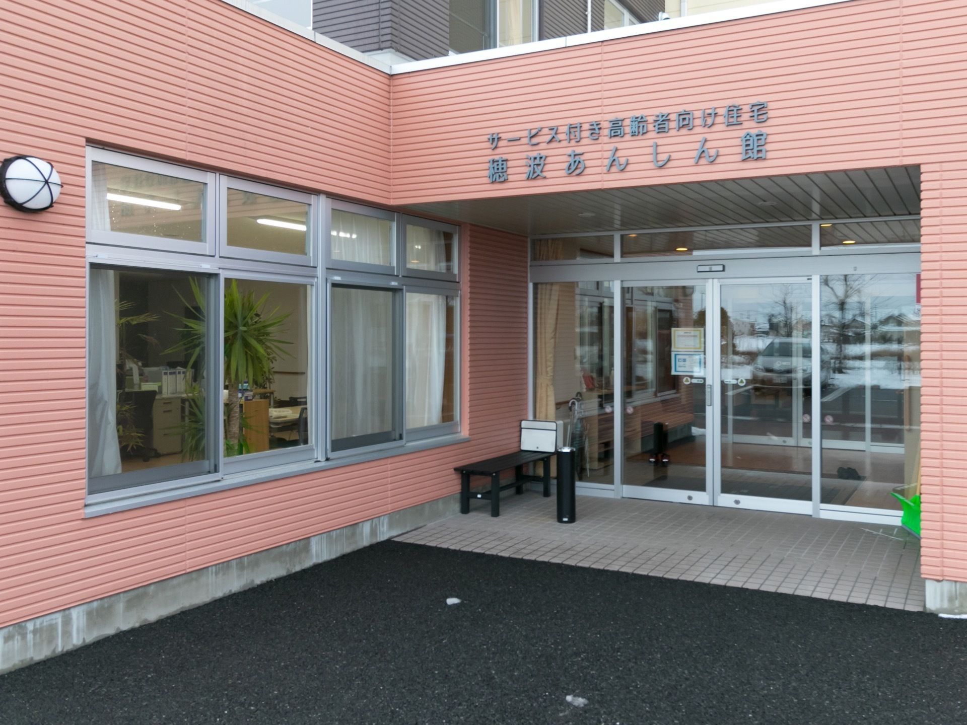 施設はデイサービス併設の3階建て介護付有料老人ホームである。ガラスサッシの自動扉や窓の設置で内外の見通しを良くしている。
