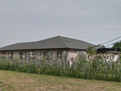自然豊かな閑静な場所に建てられた、１階建ての大きなグループホームである。目の前には原っぱが広がっている。