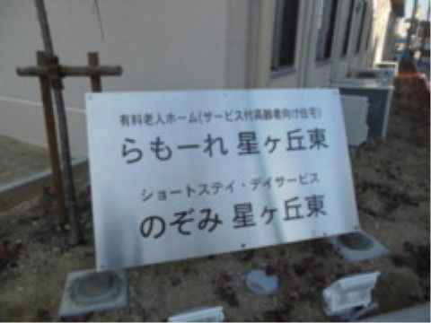 支柱が立っている木の前にある、施設名称が書かれた看板