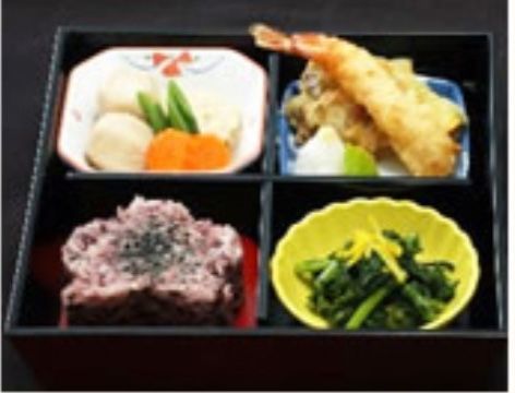 花の形に盛り付けられた赤飯と、海老の天ぷらや芋の煮物、お浸しのセット