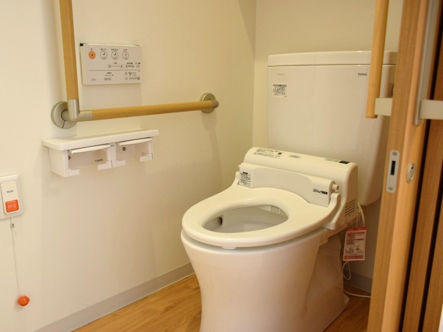 トイレは壁に設置されたパネルで操作する、温水洗浄便座を用意している。トイレットペーパーホルダーが２か所にある。